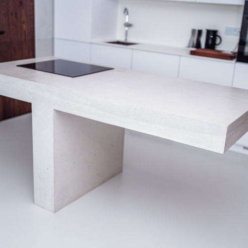 Betonový kuchyňský ostrůvek vytvořený na míru ze směsi bílého betonu pro novou moderní kuchyň.