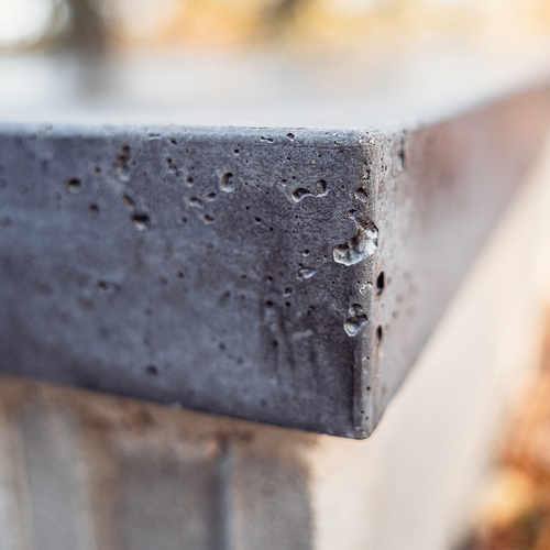 Zahradní betonová lavice - Detailní záběr tmavě šedé betonové desky zahradní lavice